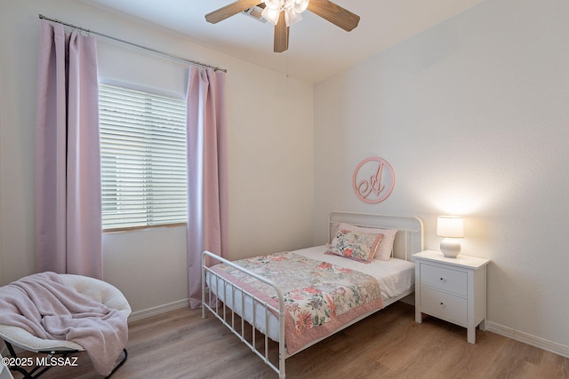 bedroom with light wood-style floors, baseboards, and a ceiling fan
