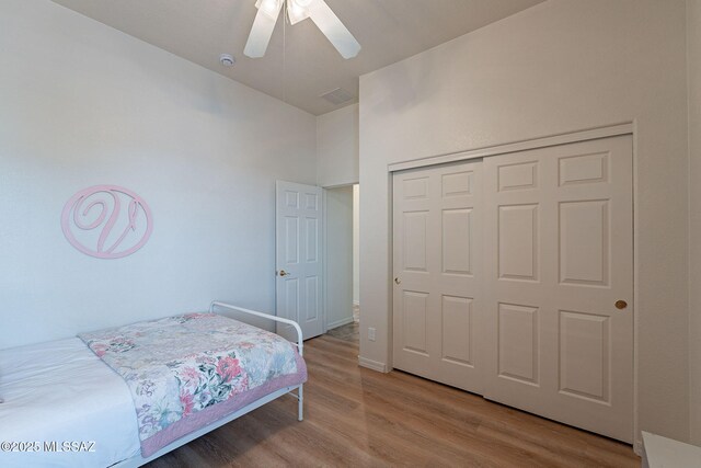 bedroom with wood finished floors, a closet, and ceiling fan