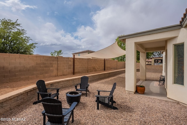 fenced backyard with a patio and a fire pit