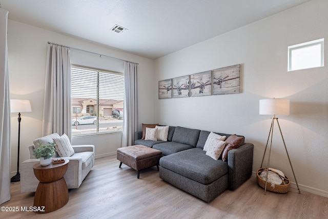 living area featuring light wood-style floors and baseboards