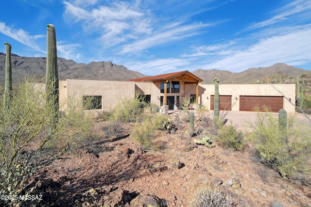 6695 W Banded Gecko Way, Tucson, AZ 85745 - view of front of house featuring stucco siding, a mountain view, an attached garage, and driveway
