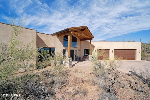 6695 W Banded Gecko Way, Tucson, AZ 85745 - rear view of house with concrete driveway, stucco siding, and a garage