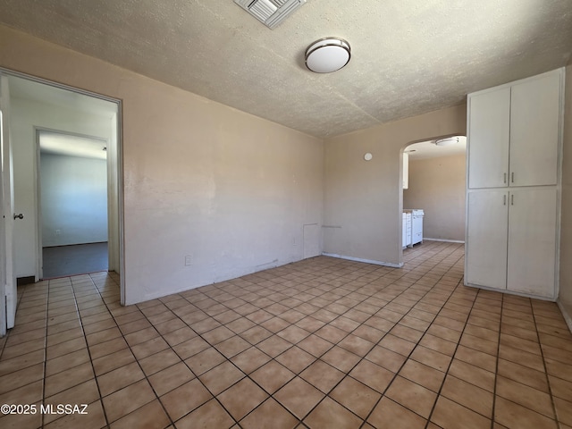 3638 S Bronson Ave, Tucson, AZ 85713 - unfurnished room featuring arched walkways, a textured ceiling, and light tile patterned floors