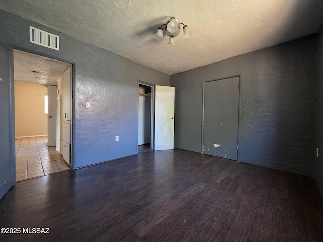 3638 S Bronson Ave, Tucson, AZ 85713 - unfurnished bedroom with a textured wall, wood finished floors, and a textured ceiling