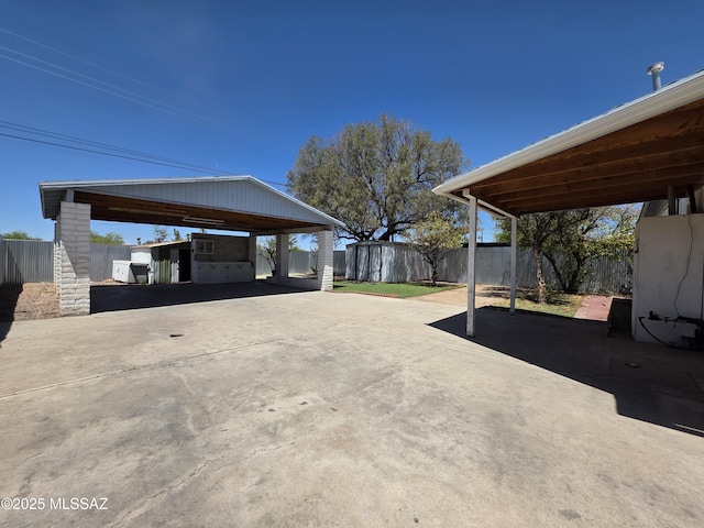 3638 S Bronson Ave, Tucson, AZ 85713 - view of car parking with a storage unit, fence, driveway, and a carport