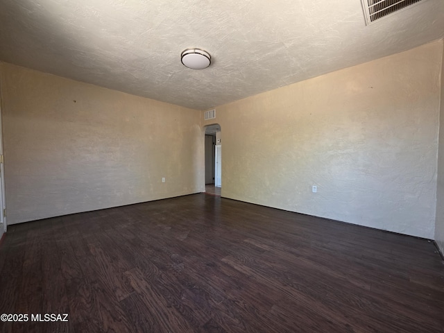 3638 S Bronson Ave, Tucson, AZ 85713 - unfurnished room with arched walkways and dark wood-style flooring