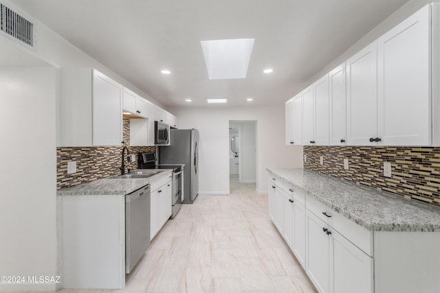 4029 E Fort Lowell Rd, Tucson, AZ 85712 - kitchen featuring a sink, appliances with stainless steel finishes, tasteful backsplash, recessed lighting, and a skylight