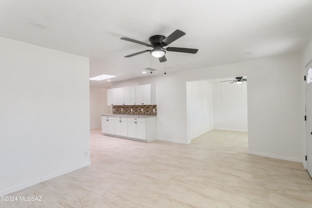 4029 E Fort Lowell Rd, Tucson, AZ 85712 - unfurnished living room with ceiling fan, a skylight, and baseboards