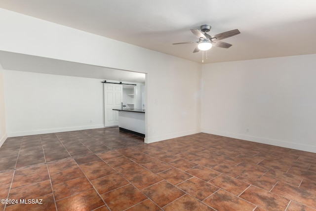 4367 N Radin Ave, Tucson, AZ 85705 - unfurnished room with baseboards, a barn door, and a ceiling fan