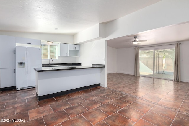 4367 N Radin Ave, Tucson, AZ 85705 - kitchen featuring a healthy amount of sunlight, white refrigerator with ice dispenser, a sink, a peninsula, and dark countertops