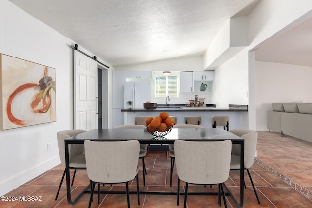 4367 N Radin Ave, Tucson, AZ 85705 - dining area featuring baseboards, a barn door, and vaulted ceiling