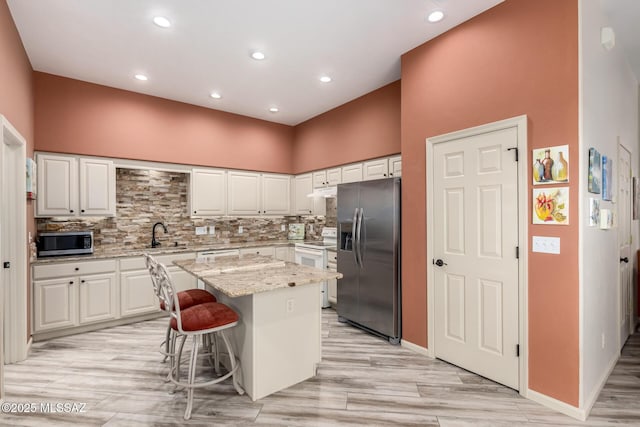1497 W Carmel Pointe Dr, Oro Valley, AZ 85737 - kitchen featuring stainless steel appliances, a center island, white cabinets, recessed lighting, and a high ceiling