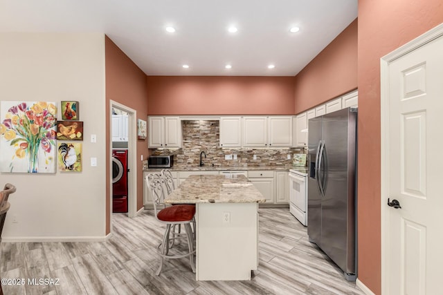 1497 W Carmel Pointe Dr, Oro Valley, AZ 85737 - kitchen featuring appliances with stainless steel finishes, a sink, white cabinets, a center island, and a breakfast bar