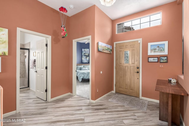 1497 W Carmel Pointe Dr, Oro Valley, AZ 85737 - foyer entrance featuring light wood finished floors, baseboards, a towering ceiling, and a chandelier