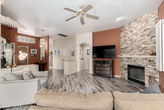 1497 W Carmel Pointe Dr, Oro Valley, AZ 85737 - living room featuring ceiling fan, wood finished floors, arched walkways, and a stone fireplace