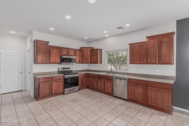 10560 E Forest Falls Ct, Tucson, AZ 85747 - kitchen featuring appliances with stainless steel finishes, recessed lighting, a sink, light tile patterned floors, and brown cabinetry