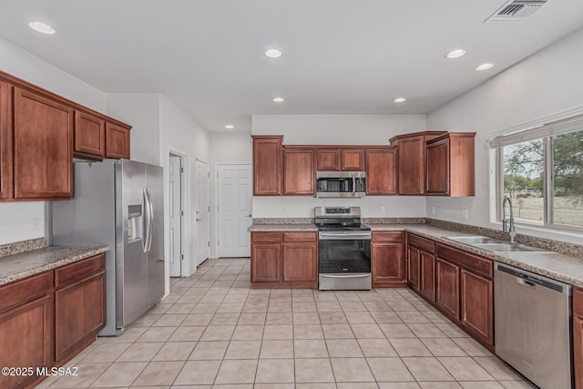 10560 E Forest Falls Ct, Tucson, AZ 85747 - kitchen with appliances with stainless steel finishes, a sink, recessed lighting, light tile patterned floors, and brown cabinets