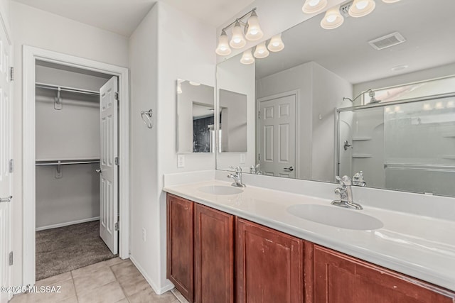 10560 E Forest Falls Ct, Tucson, AZ 85747 - full bath featuring tile patterned flooring, a shower stall, double vanity, a walk in closet, and baseboards