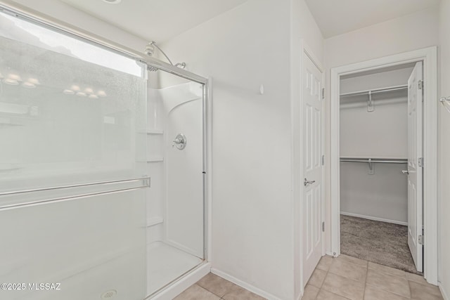 10560 E Forest Falls Ct, Tucson, AZ 85747 - full bathroom with a stall shower, tile patterned flooring, a spacious closet, and baseboards