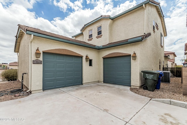 10560 E Forest Falls Ct, Tucson, AZ 85747 - view of front of property featuring stucco siding, driveway, central AC unit, and fence