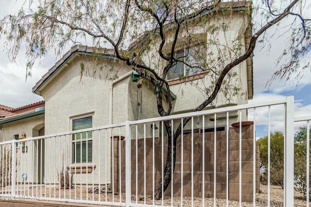 10560 E Forest Falls Ct, Tucson, AZ 85747 - view of property exterior featuring stucco siding, fence, and a tile roof