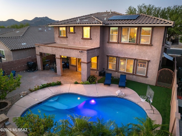3443 W Tailfeather Dr, Marana, AZ 85658 - rear view of property with roof mounted solar panels, a fenced backyard, a mountain view, and a patio area