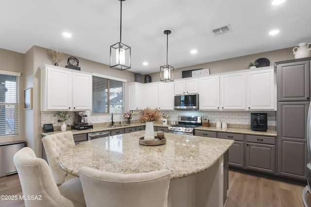 3443 W Tailfeather Dr, Marana, AZ 85658 - kitchen featuring appliances with stainless steel finishes, a center island, backsplash, light wood-style floors, and recessed lighting
