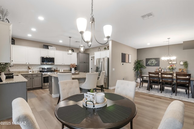 3443 W Tailfeather Dr, Marana, AZ 85658 - dining room featuring recessed lighting, light wood finished floors, and a chandelier