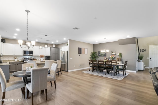 3443 W Tailfeather Dr, Marana, AZ 85658 - dining room featuring a chandelier, recessed lighting, baseboards, and light wood-type flooring