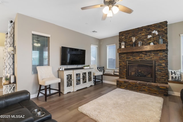 3443 W Tailfeather Dr, Marana, AZ 85658 - living area featuring a stone fireplace, wood finished floors, and ceiling fan