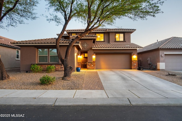 3443 W Tailfeather Dr, Marana, AZ 85658 - mediterranean / spanish house featuring concrete driveway, stone siding, a garage, and a tile roof