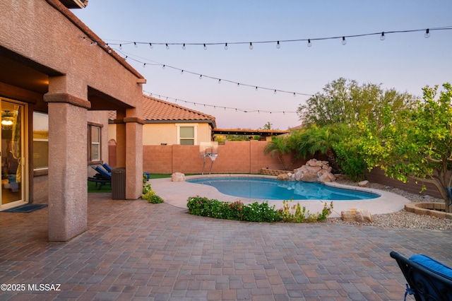 3443 W Tailfeather Dr, Marana, AZ 85658 - pool at dusk featuring a fenced backyard and a patio area
