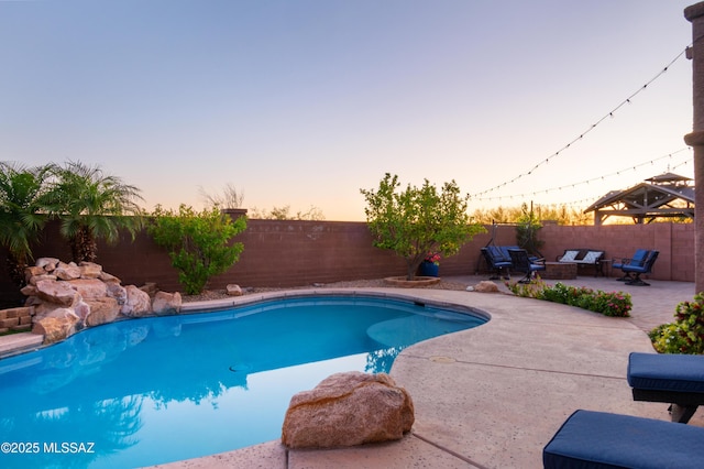 3443 W Tailfeather Dr, Marana, AZ 85658 - pool at dusk featuring a patio and a fenced backyard