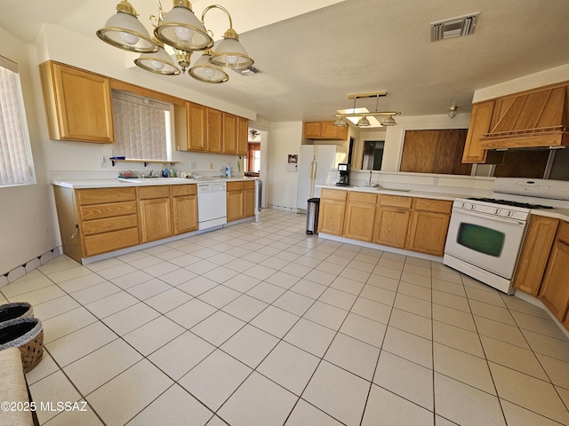 1760 W Airport Rd, Willcox, AZ 85643 - kitchen featuring white appliances, light countertops, a chandelier, a sink, and hanging light fixtures