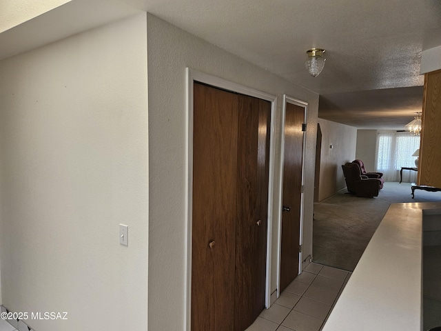 1760 W Airport Rd, Willcox, AZ 85643 - corridor with tile patterned floors, carpet flooring, and a chandelier