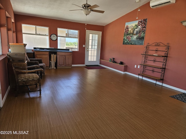 1760 W Airport Rd, Willcox, AZ 85643 - sitting room with a wall unit AC, a ceiling fan, vaulted ceiling, baseboards, and dark wood-style flooring