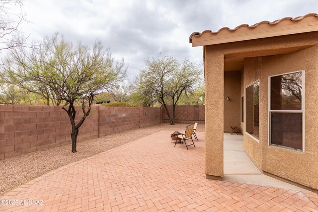 4161 W Diamond Butte Ct, Tucson, AZ 85745 - view of patio with a fenced backyard and an outdoor fire pit