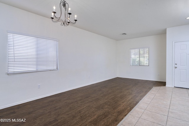 803 W Calle Muro Fuerte Dr, Sahuarita, AZ 85629 - empty room featuring a chandelier, wood finished floors, and baseboards