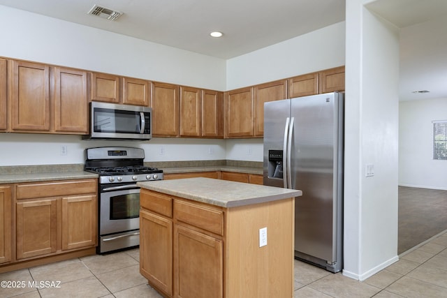 803 W Calle Muro Fuerte Dr, Sahuarita, AZ 85629 - kitchen with appliances with stainless steel finishes, light tile patterned floors, a kitchen island, light countertops, and brown cabinetry