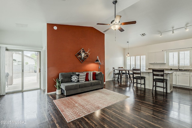 living room with a ceiling fan, dark wood-style flooring, lofted ceiling, and baseboards