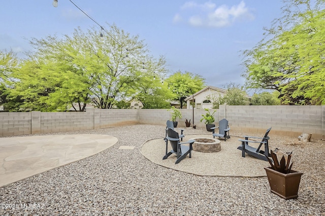 fenced backyard featuring an outdoor fire pit and a patio