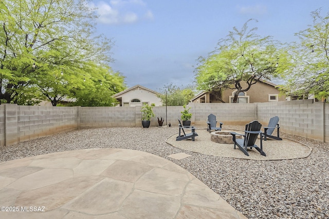 fenced backyard featuring an outdoor fire pit and a patio area