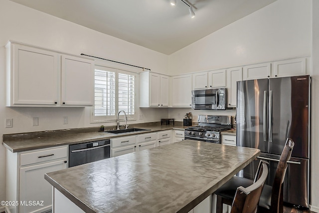 kitchen featuring appliances with stainless steel finishes, a sink, dark countertops, white cabinets, and high vaulted ceiling