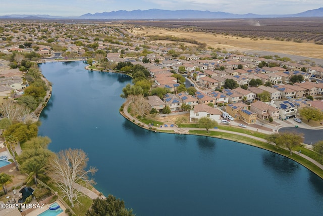 aerial view of property and surrounding area with a water and mountain view and nearby suburban area