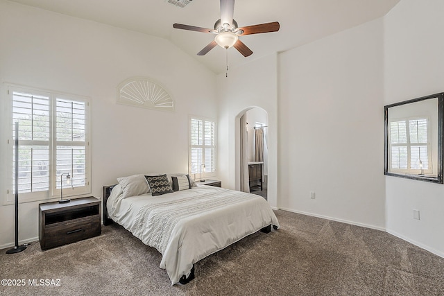 bedroom with carpet floors, arched walkways, high vaulted ceiling, baseboards, and a ceiling fan