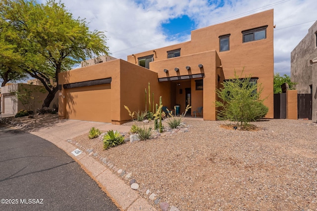 4296 N Rillito Creek Pl, Tucson, AZ 85719 - pueblo-style home with stucco siding, asphalt driveway, a garage, and fence