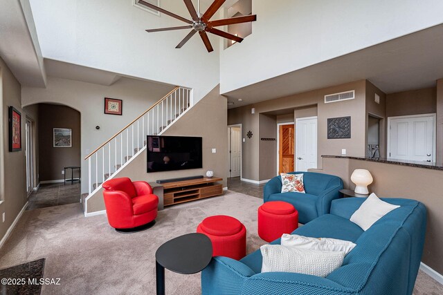 4296 N Rillito Creek Pl, Tucson, AZ 85719 - living room featuring stairs, ceiling fan, arched walkways, baseboards, and carpet flooring