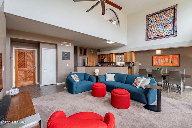 4296 N Rillito Creek Pl, Tucson, AZ 85719 - carpeted living room with a ceiling fan, baseboards, a towering ceiling, and tile patterned floors