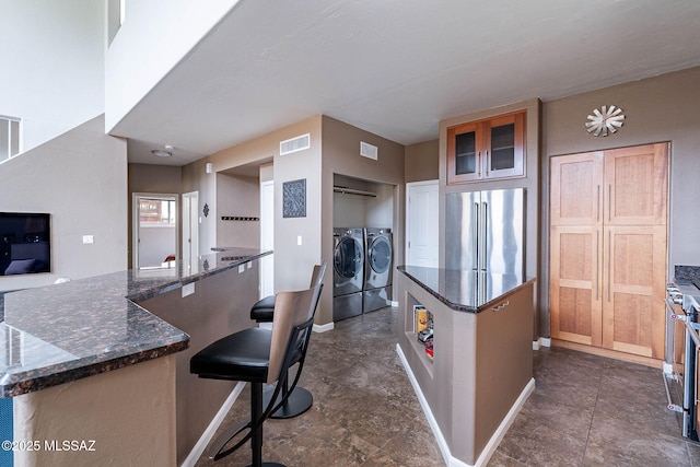 4296 N Rillito Creek Pl, Tucson, AZ 85719 - kitchen featuring high end fridge, independent washer and dryer, a kitchen island, baseboards, and dark stone counters