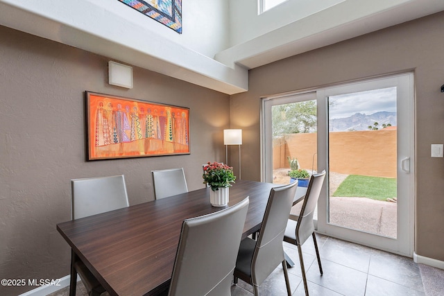 4296 N Rillito Creek Pl, Tucson, AZ 85719 - dining space featuring light tile patterned floors, a textured wall, and baseboards